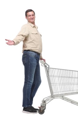 Beyaz arka planda izole edilmiş boş bir alışveriş arabasını iten genç adamın yan görüntüsü