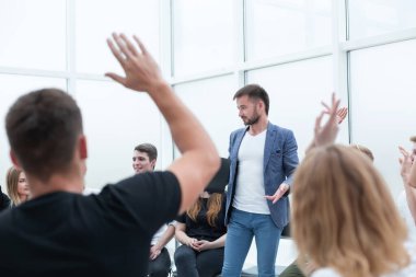 Konuşmacı iş seminerindeki izleyicilere sorular soruyor. iş ve eğitim
