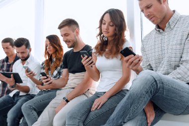 ofis lobisinde oturan bir taşınabilir aygıt kullanarak iş takım.