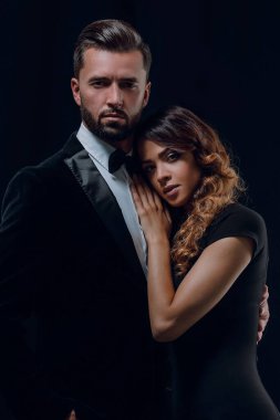 Stüdyoda klasik kıyafetler içinde birbirine aşık genç bir çiftin portresi.