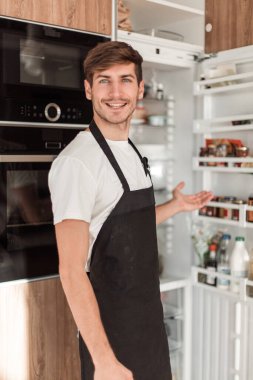 onun rahat mutfakta çekici genç adam ayakta