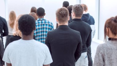 Dikiz aynası. Bir grup genç ofis lobisinde duruyor.