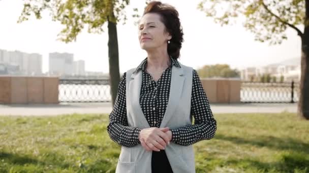 Retrato de la señora mayor feliz de pie en la ciudad moderna al aire libre sonriendo agradable vida urbana — Vídeo de stock