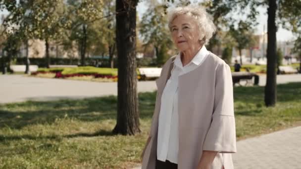 행복 한 할머니가 거리를 돌아다니며 웃고 있는 느린 동작 — 비디오