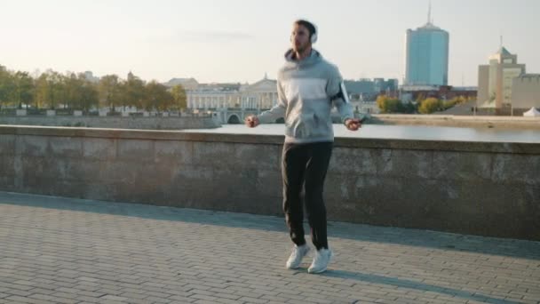 Retrato de homem jovem apto pulando com corda concentrada em atividade saudável no dia de verão — Vídeo de Stock