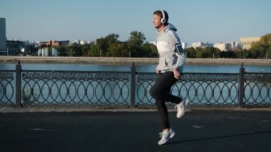 Nehir kenarındaki sette ip atlayan genç adamın yavaş çekim görüntüsü