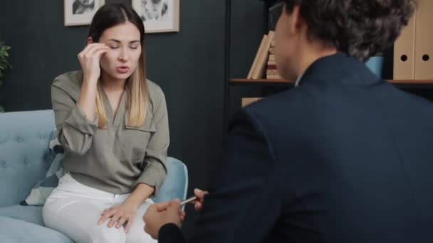 専門家は耳を傾け 助けとアドバイスを与えている間 オフィスでの治療セッション中に怒りを表現怒っている若い女性の肖像画 — ストック動画