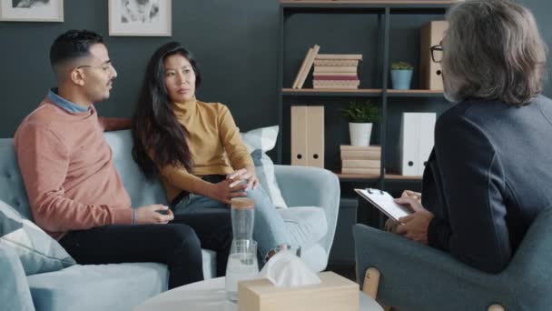 Middle Eastern guy and Asian girl fighting during family therapy session with psychologist — Stock Video