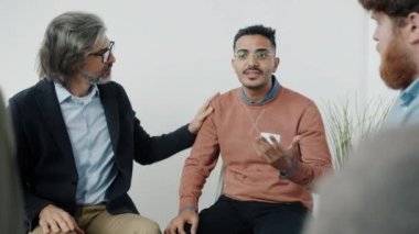 Öfkeli Orta Doğulu adam bağırıyor sonra grup terapisini bırakıyor sonra da insanlar psikologla sorunlarını tartışıyor.