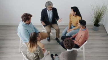 Psikolog çeşitli hastalarla el ele tutuşup yardım ve destek öneriyor.