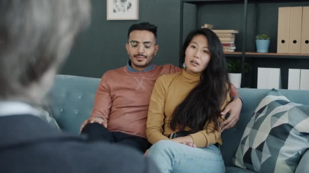 Joven marido y mujer birracial hablando de problemas familiares con psicólogo — Vídeos de Stock