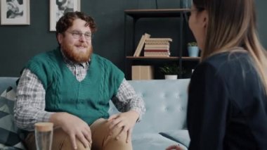 Sinirli genç bir adam terapi sırasında psikologla duygularını paylaşıyor.