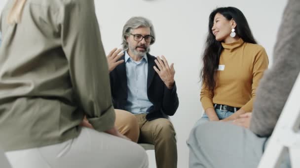 Portrait de personnes tenant la main parlant et souriant lors d'une thérapie de groupe à l'intérieur — Video