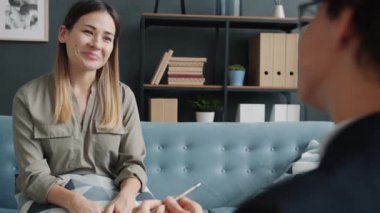 Neşeli genç bayan terapistle konuşuyor, gülümsüyor, rahatlıyor ve mutlu oluyor.