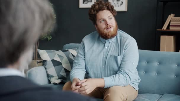 Homem adulto com comportamento estranho conversando com o terapeuta durante a sessão no escritório moderno — Vídeo de Stock