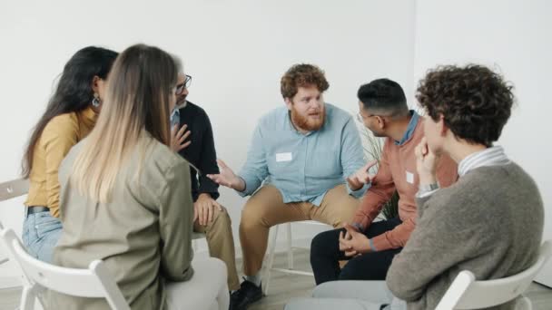 Hombre enojado gritando y luego dejando la reunión del grupo de apoyo luego hombres y mujeres discutiendo la situación con el terapeuta — Vídeo de stock