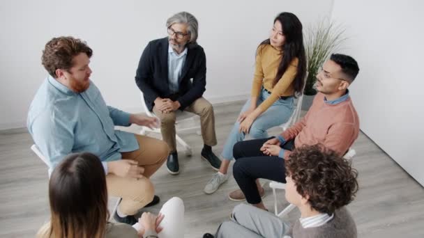Visão de alto ângulo de pessoas citando em círculo conversando e gesticulando durante a terapia de grupo — Vídeo de Stock