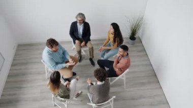 Sorunlu adam grup terapisinde duyguları tartışan insanlarla sorunları paylaşıyor.