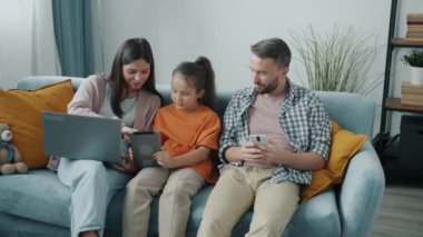 Neşeli kadın ve erkek modern aletler kullanarak online içeriği tartışıyor ve aletlerin tadını çıkarıyor.