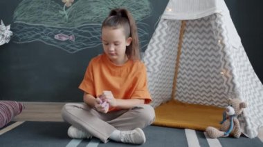 Neşeli çocuk, kille oynuyor. Gülümsüyor, evde tek başına eğleniyor.