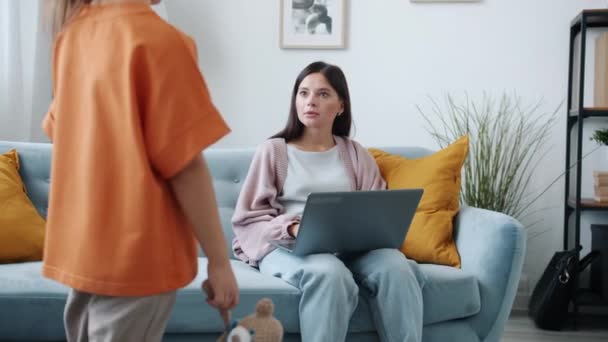 Jonge vrouw freelancer werken met laptop wanneer vervelende kind komen veeleisende aandacht — Stockvideo