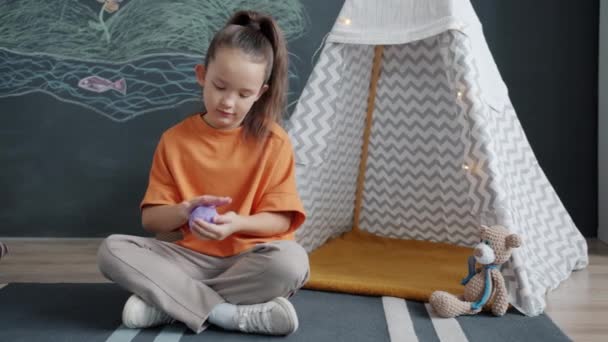 Copil vesel joc cu modelare lut zâmbind se bucură de joc la domiciliu singur — Videoclip de stoc