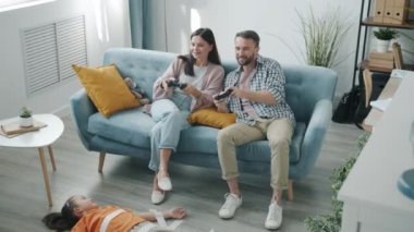 Anne ve baba video oyunu oynarken çocuk koli bandıyla yere yapışmış.