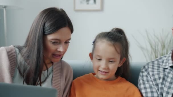 Schattig kind met behulp van gadget en praten met moeder en vader lachen plezier samen — Stockvideo