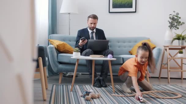 Man thuis praten op mobiele telefoon terwijl kind chatten spel lastig vader — Stockvideo