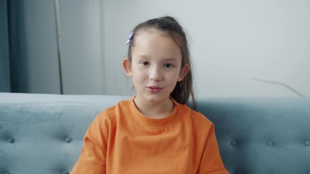 Портрет жизнерадостного ребенка, говорящего во время онлайн-видеозвонка, смотрящего на камеру в помещении — стоковое видео