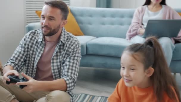 Cámara lenta del padre y el niño jugando videojuego ganar haciendo alta-cinco gesto de mano con la madre — Vídeo de stock