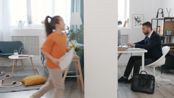 Vater arbeitet mit Computer, während kleine Tochter spricht, stört Mann zu Hause — Stockvideo