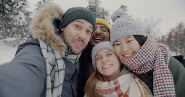 겨울에 숲 속에서 셀피 카메라를 보면서 셀피를 찍고 있는 행복 한 친구들 의 POV 사진 — 비디오
