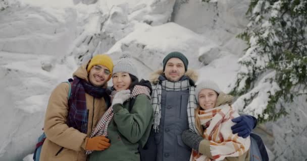 Portrait de joyeux milléniaux souriant regardant la caméra dans la forêt d'hiver pendant les chutes de neige — Video