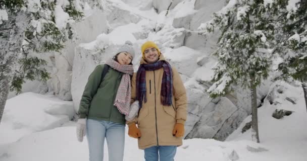 Αργή κίνηση πορτρέτο του χαρούμενος νεαρός άνδρας και η γυναίκα στέκεται στο δάσος το χειμώνα απολαμβάνοντας το ταξίδι — Αρχείο Βίντεο