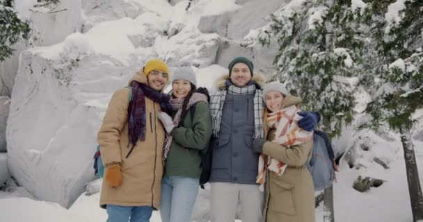 Män och kvinnor i aktiva kläder står utomhus i vinterskogen leende skrattar — Stockvideo