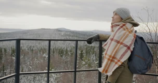 Langsom bevægelse af glad ung kvinde nyder vinteren naturbjerge og skov stående på observationsstedet udenfor – Stock-video