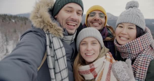 冬の日に山の中で屋外でオンラインビデオ通話を楽しむ幸せな友人 — ストック動画