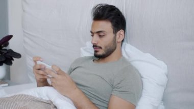 Gamsız Orta Doğulu adam akıllı telefonuyla oynuyor. Oyun uygulamasının keyfini çıkarıyor.