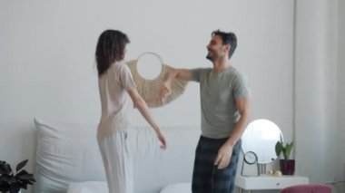 Karı kocanın yavaş çekimde çekilmiş portresi. Karışık ırk çiftleri evde dans edip yatakta zıplıyorlar.