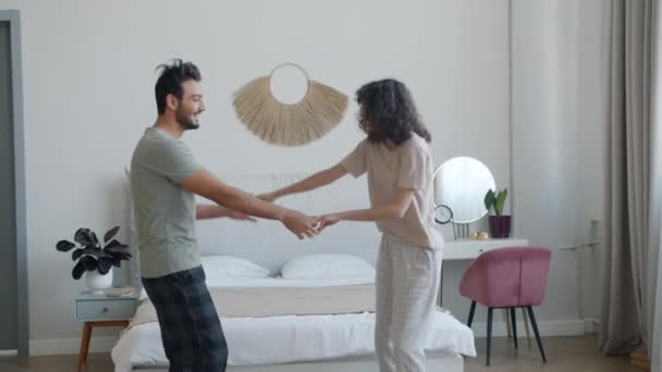 Boldog férj és feleség táncol a hálószobában élvezi a zenét és romantikus pillanatok otthon — Stock videók