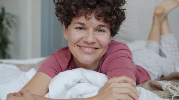 Slow motion portrait of gorgeous lady wearing pajamas lying in bed in apartment — Stock Video