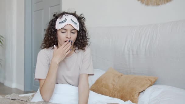 Chica soñolienta bostezando acostada en la cama poniéndose la máscara del sueño y disfrutando de la siesta — Vídeos de Stock