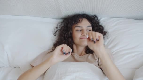Cámara lenta de hermosa mujer joven bailando en la cama divirtiéndose sola — Vídeos de Stock