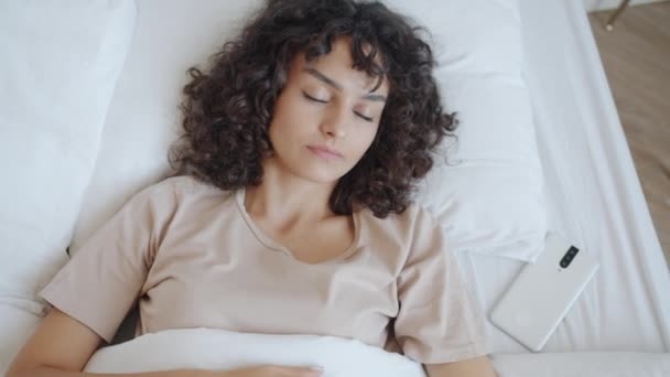 Glada flicka bär pyjamas vakna upp i sängen hemma vidröra smartphone skärm sedan stretching armar — Stockvideo