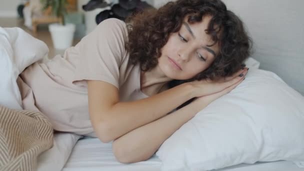 Slow motion portret van aantrekkelijke meisje dragen pyjama zetten hoofd naar beneden op kussen en slapen — Stockvideo