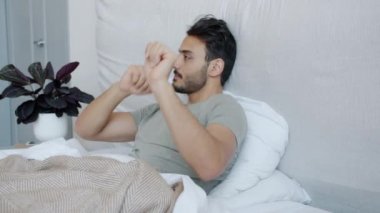 Neşeli Orta Doğulu adam yatakta dans ediyor kaygısızca eğleniyor.