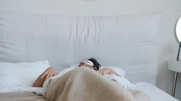 Портрет отдохнувшего араба, проснувшегося, снимающего маску и улыбающегося в постели — стоковое видео