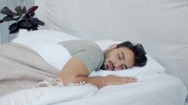 Uyuyan yakışıklı bir Arap 'ın portresi. Sonra uyanıp evde akıllı telefonları kontrol ediyor.