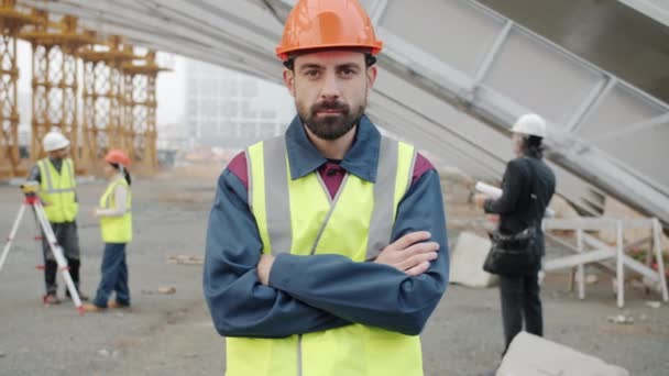 Portrait d'un employé de la construction portant un uniforme debout à l'extérieur sur le lieu de travail — Video